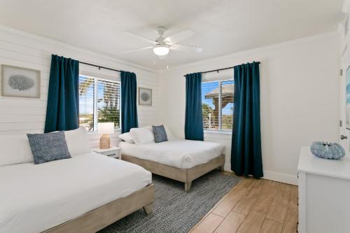 une chambre avec deux lits et des rideaux bleus dans l'établissement The Molloy - A Boutique Beach Resort, à St. Pete Beach