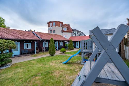 a house with a playground in the yard at Baltic Apartment Rewal - Bartek in Rewal