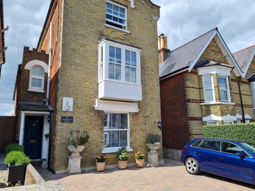 a blue car parked in front of a brick house at Endeavour House in Cowes