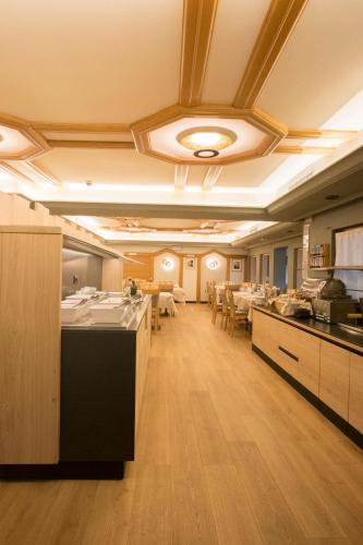 a large room with a kitchen and a dining room at Hotel La Montanara Predazzo in Predazzo