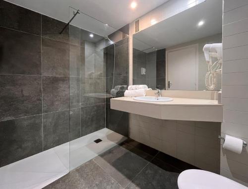 une salle de bains avec un lavabo et un miroir dans l'établissement Hotel Gran Garbi & AquaSplash, à Lloret de Mar