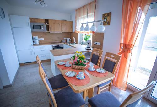 eine Küche mit einem Holztisch mit Stühlen und einer Tableasteryasteryasteryastery in der Unterkunft Ferienwohnung Nähe Legoland Günzburg 86 qm mit Balkon in Burtenbach