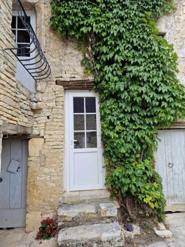 a white door on the side of a building at La Petite Ecluse, maison d'artistes in Tanlay