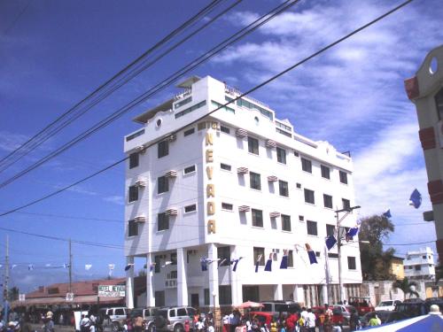 un edificio blanco con gente parada frente a él en Hotel Gran Nevada Playas, en Playas