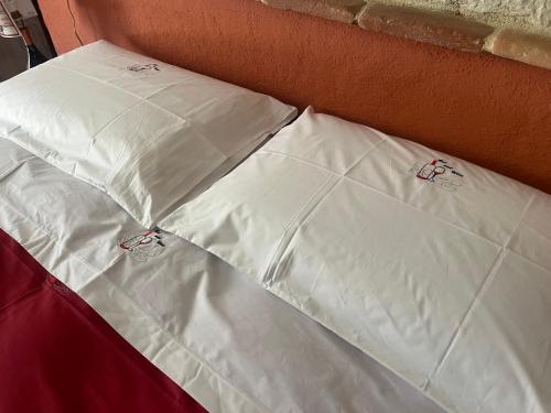 a pile of white pillows sitting on a bed at Bed and Wine in Papiano