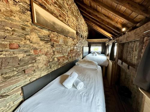 two beds in a room with a brick wall at Le Cent Quarante in Spa