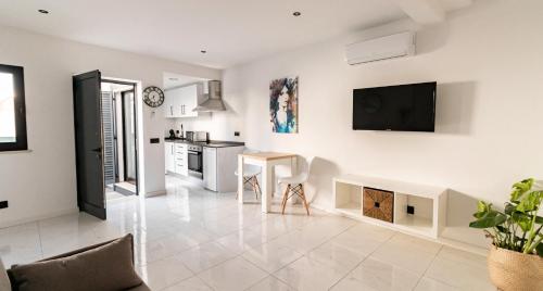a kitchen and living room with a tv on the wall at Mi Casa Es Su Casa Nº1 in Albufeira