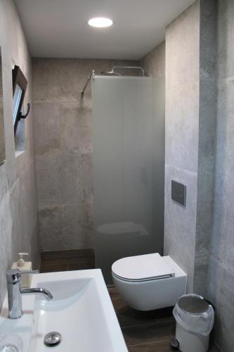a bathroom with a white toilet and a sink at Villa IVIA in Mándra