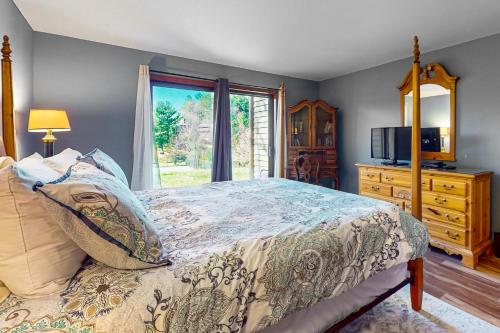 a bedroom with a bed and a window at Cardinal 104 in Blowing Rock