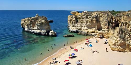 a group of people on a beach near the ocean at Mi Casa Es Su Casa Nº5 in Albufeira