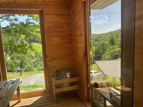 a view from the inside of a cabin with a large window at Cabanele din Valea Ursului in Bîrsana