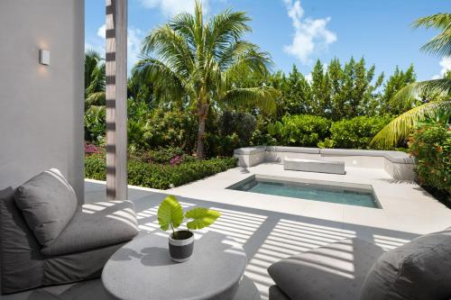 a patio with a pool and a chair and a table at South Bank in Long Bay Hills