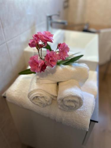 a bouquet of pink flowers sitting on top of towels at Casin de Mori - intero appartamento 80mq- in Penna