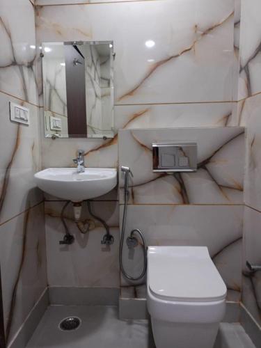 a bathroom with a white toilet and a sink at Hotel C G Newly Built 2 Mins From Connaught Place and Railway Station & 5 Mins From VFS Shivaji Stadium Metro Station in New Delhi