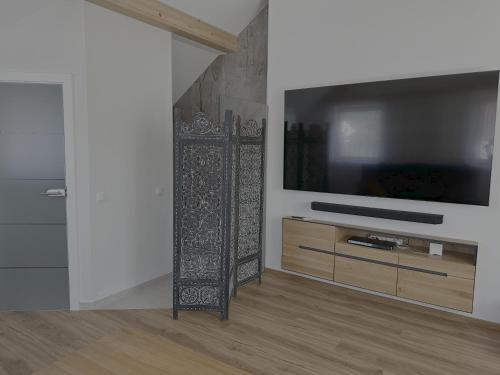 a living room with a flat screen tv in a room at Villa Racing - Privatzimmer in Spielberg in Spielberg