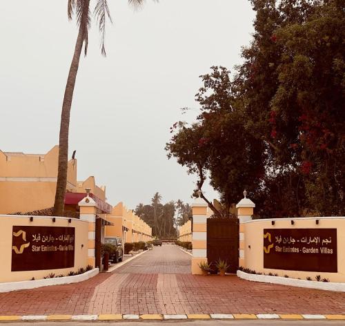 a street with a palm tree and a building at Star Emirates Garden Villas Salalah in Salalah