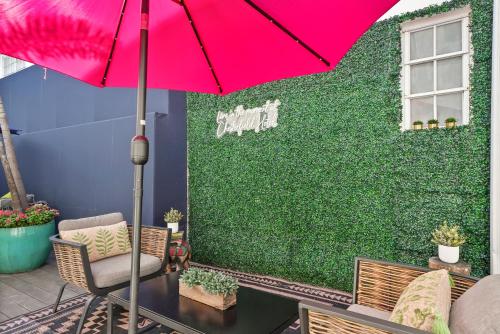 a red umbrella on a patio with a green wall at Chesterfield Hotel & Suites in Miami Beach