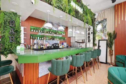 a bar with green chairs in a restaurant at Chesterfield Hotel & Suites in Miami Beach