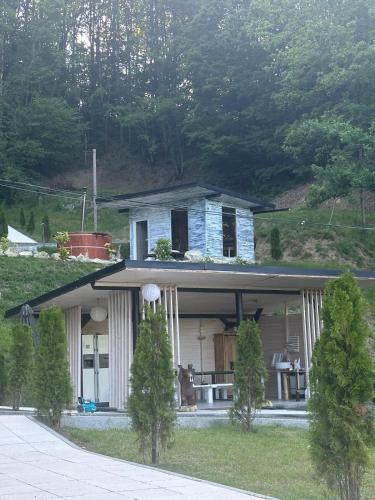 a house with a porch with a table in front of it at Cabanele din Valea Ursului in Bîrsana