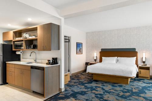 a hotel room with a bed and a kitchen at Hampton Inn St Ignace Lakefront Mackinac in Evergreen Shores