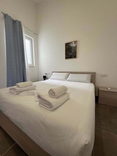 a bedroom with a white bed with towels on it at Serene Living New 2 Bed in Taʼ Penza