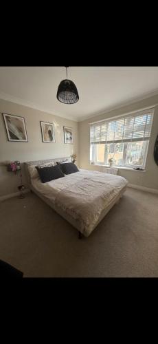 a bedroom with a large bed and two windows at Stylish seafront flat in Hove in Brighton & Hove