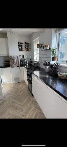 a kitchen with a black and white counter top at Stylish seafront flat in Hove in Brighton & Hove