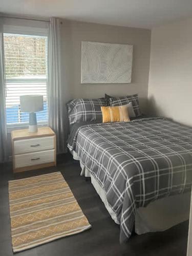 a bedroom with a bed and a lamp and a window at Cozy Chalet with Breathtaking Mountain View in Notre-Dame-Des-Bois