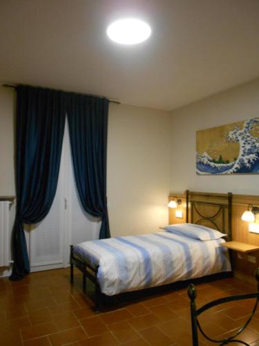 a bedroom with a bed with blue curtains at Nippon Tranquillity in Carobbio degli Angeli