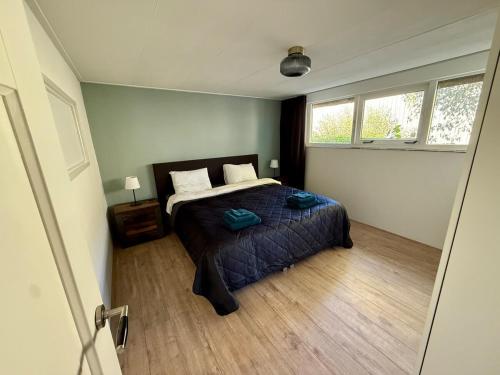 Un dormitorio con una cama en una habitación con ventana. en Holiday Home de Binnengouw, en Hoogwoud