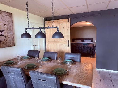 a dining room table and chairs with a table and a bed at Holiday Home de Binnengouw in Hoogwoud