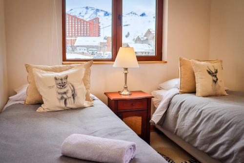a room with two beds and a lamp and a window at HOM I Valle Nevado de Lujo 4D3B Ski in-out Piscina in Lo Barnechea