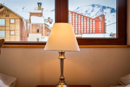 a lamp sitting on a table in front of a window at HOM I Valle Nevado de Lujo 4D3B Ski in-out Piscina in Lo Barnechea