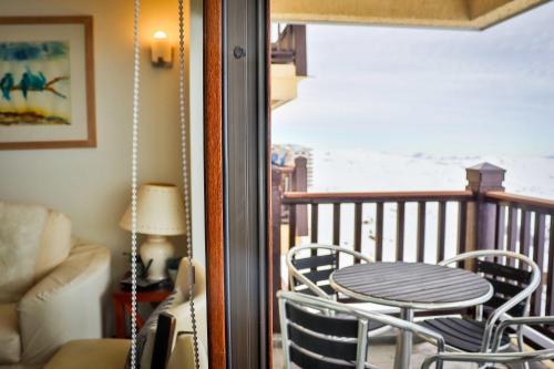 a porch with a table and chairs on a balcony at HOM I Valle Nevado de Lujo 4D3B Ski in-out Piscina in Lo Barnechea