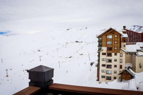 a building with a snow covered mountain in the background at HOM I Valle Nevado de Lujo 4D3B Ski in-out Piscina in Lo Barnechea