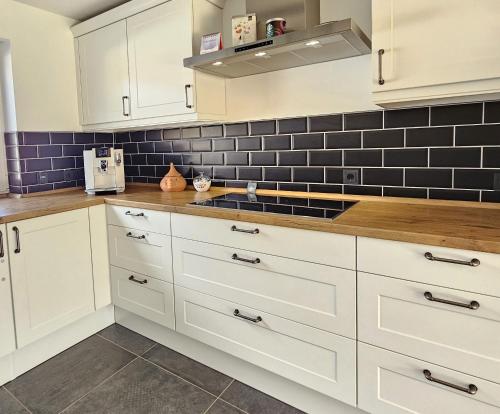 a kitchen with white cabinets and a sink at Private room`s Aitrach, style, comfort, Quiet, motorway connection in Aitrach