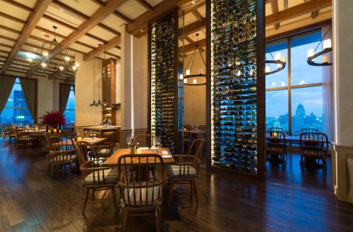 a restaurant with tables and chairs and wine bottles at Radisson Blu Plaza Bangkok in Bangkok