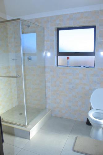 a bathroom with a shower and a toilet at Arrival Center BnB in Maseru