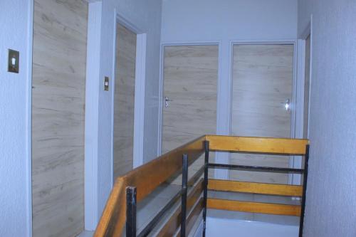 a stairway with a wooden railing in a building at Arrival Center BnB in Maseru