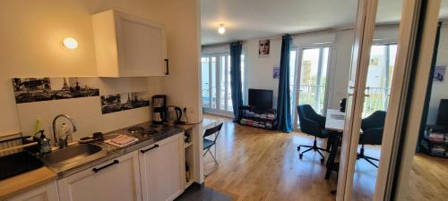 Il comprend une cuisine avec un évier et un bureau avec des chaises. dans l'établissement Superbe Studio Fort d'Issy - Idéal professionnel ou vacancier, à Issy-les-Moulineaux