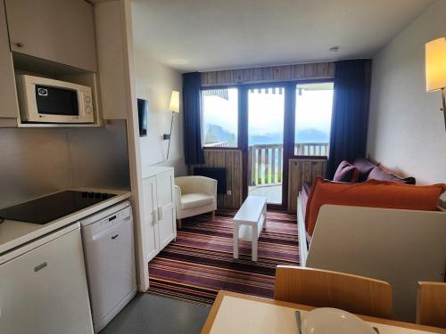 une petite cuisine et un salon avec un canapé et un micro-ondes dans l'établissement Avoriaz - Appartement cosy 4 pers avec balcon ensoleillé - FR-1-633-85, à Morzine