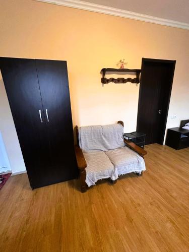 a living room with two black cabinets and a chair at Glori in Tbilisi City