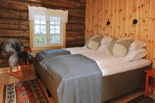 - une chambre avec un grand lit dans une cabane en rondins dans l'établissement Bjerkeløkkja Bed and Breakfast, à Oppdal