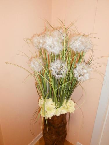 a vase filled with white flowers and grass at Nippon Tranquillity in Carobbio degli Angeli