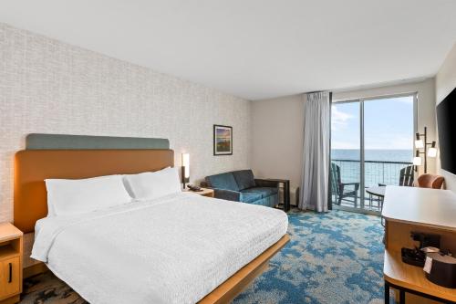 a hotel room with a bed and a view of the ocean at Hampton Inn St Ignace Lakefront Mackinac in Evergreen Shores