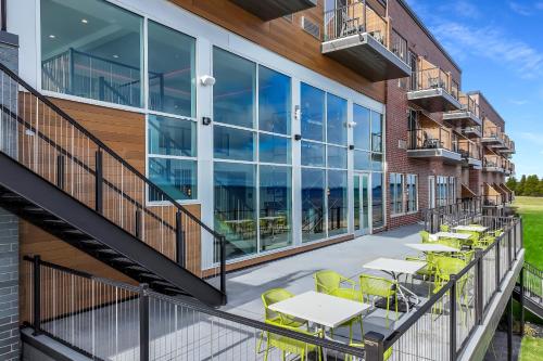 an outdoor patio with tables and yellow chairs on a building at Hampton Inn St Ignace Lakefront Mackinac in Evergreen Shores
