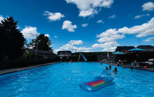 a large swimming pool with people in the water at Chez Denis et Jenni à Han sur Lesse in Han-sur-Lesse