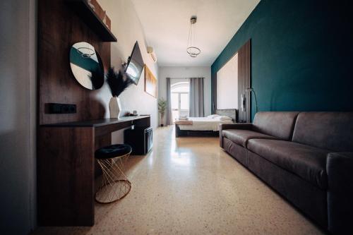 a living room with a couch and a bedroom at Rapture Gozo - Guesthouse in Xewkija