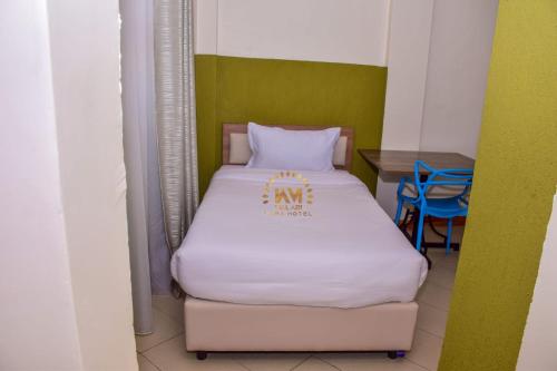 a small room with a bed with a sign on it at Walabi Mara Hotel in Narok
