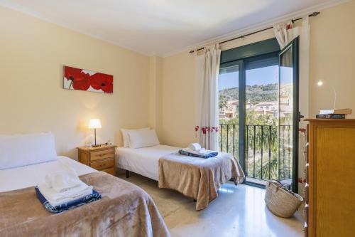 a bedroom with two beds and a balcony at Floridamar in Jávea